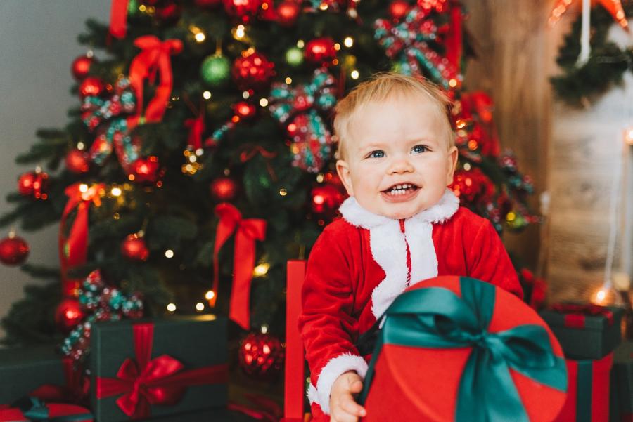 Baby med nissehue og juletræ